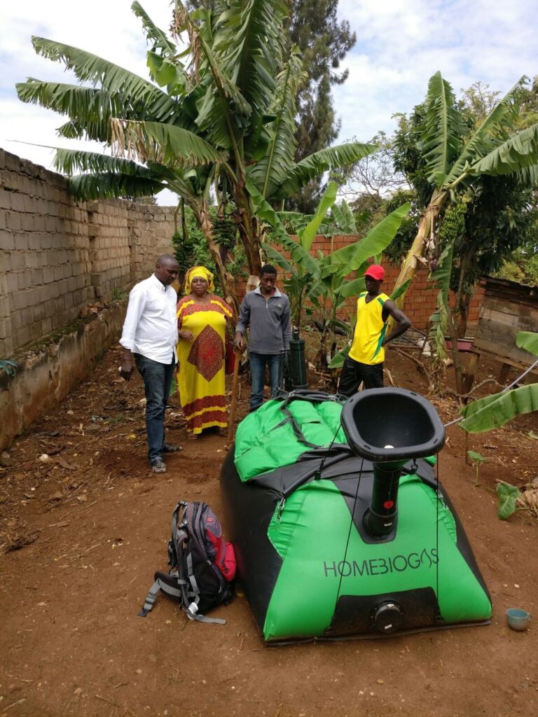 People standing next to a new Homebiogas system in Kiglali, Rwanda