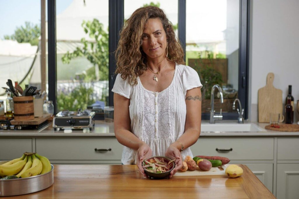 A woman displays a bowl of food scraps