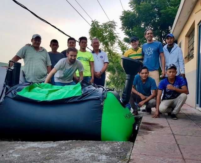 People standing next to a Homebiogas system in Guatemala